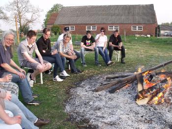 Die Stallgemeinschaft sitzt in gemütlicher Runde am Feuer